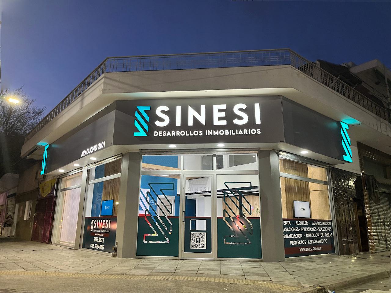 Fachada de Sinesi Desarrollos Inmobiliarios de noche